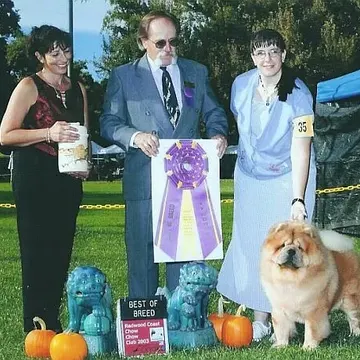 Amy, the judge and a Chow Chow with a purple Best in Specialty rosette